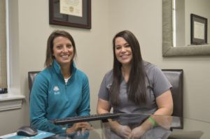 Office coordinator Kelli and dental hygienist Christie smiling together at Greenville Family Smiles