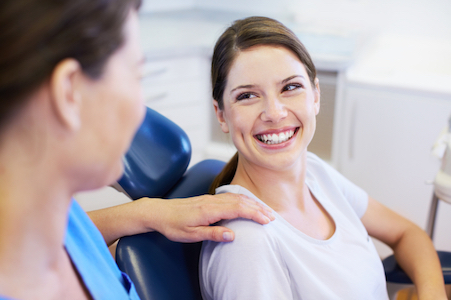 Smiling woman thanking her doctor for a painless root canal procedure.