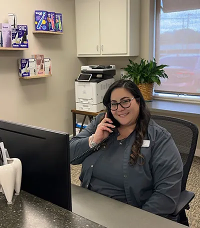 Greenville Family Smiles receptionist on the phone with a new patient